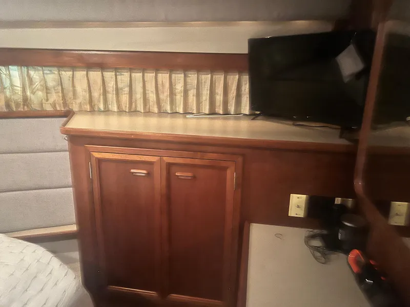 Slide: The Image of 1987 Carver 420 Cockpit Motor Yacht interior with wood cabinetry and small TV. - 24