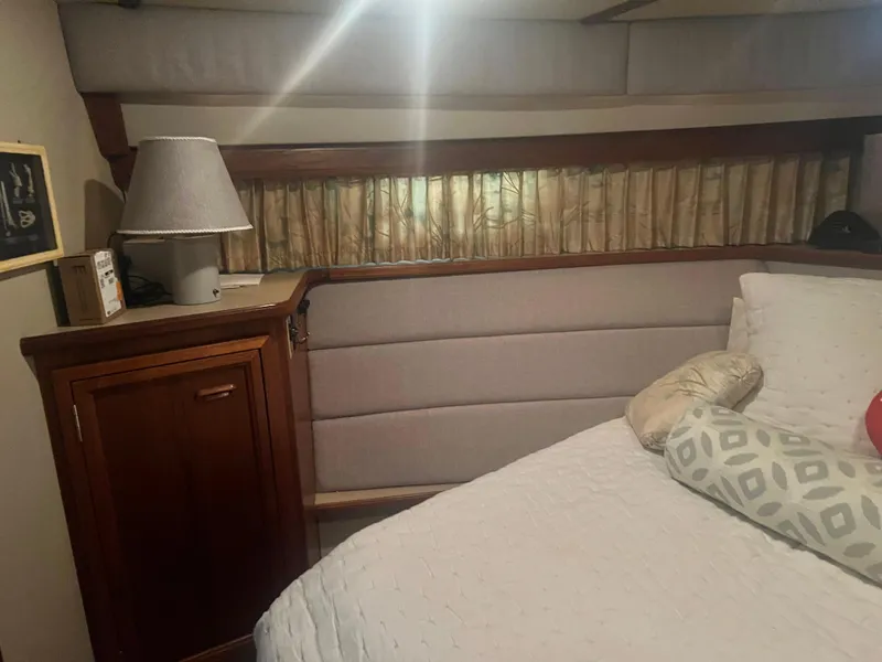Slide: The Image of Interior of 1987 Carver 420 Cockpit Motor Yacht with bed, lamp, and wooden cabinet. - 25