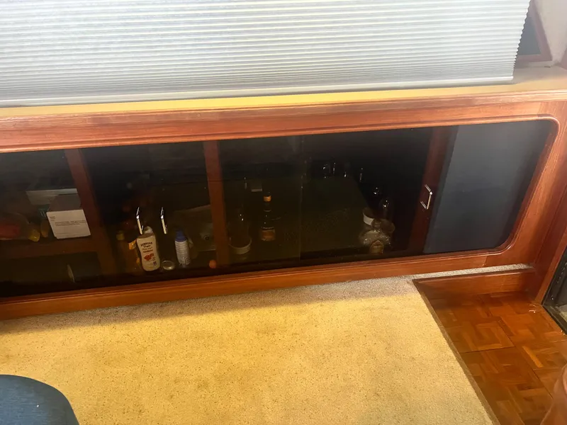 Slide: The Image of Interior of 1987 Carver 420 Cockpit Motor Yacht with wooden cabinet and carpet flooring. - 29