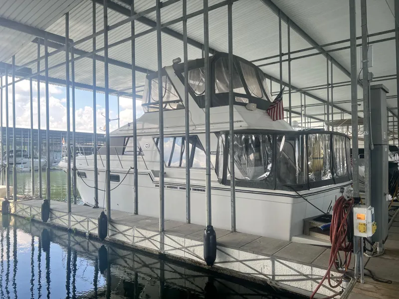 Slide: The Image of 1987 Carver 420 Cockpit Motor Yacht docked in a marina under a covered structure. - 3