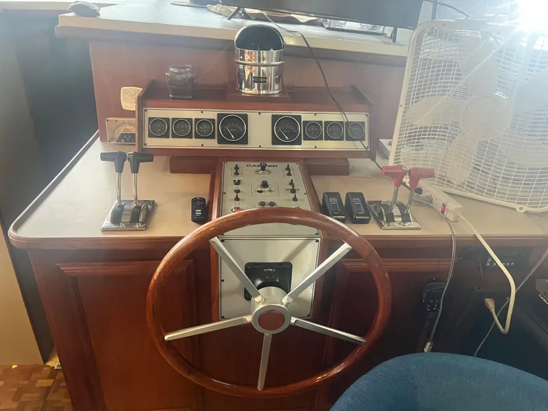 Slide: The Image of 1987 Carver 420 Cockpit Motor Yacht helm with steering wheel and control panel. - 31