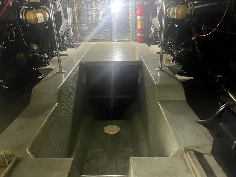 Slide: The Image of Engine room of a 1987 Carver 420 Cockpit Motor Yacht, featuring mechanical components and a fire extinguisher. - 32