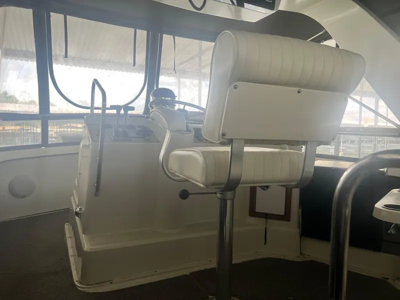 Slide: The Image of 1987 Carver 420 Cockpit Motor Yacht helm with white captain's chair and controls. - 6