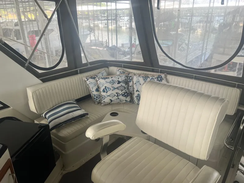 Slide: The Image of 1987 Carver 420 Cockpit Motor Yacht interior with white seating and nautical-themed pillows. - 7