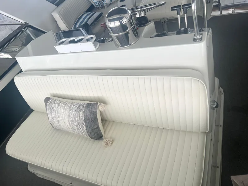 Slide: The Image of 1987 Carver 420 Cockpit Motor Yacht interior with white seating and decorative pillow. - 8
