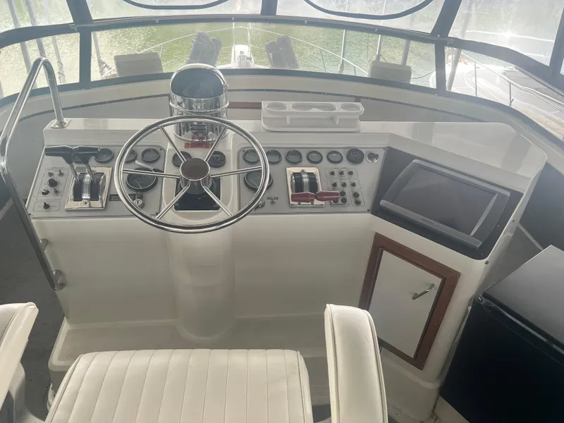 Slide: The Image of 1987 Carver 420 Cockpit Motor Yacht helm with steering wheel and control panel. - 9