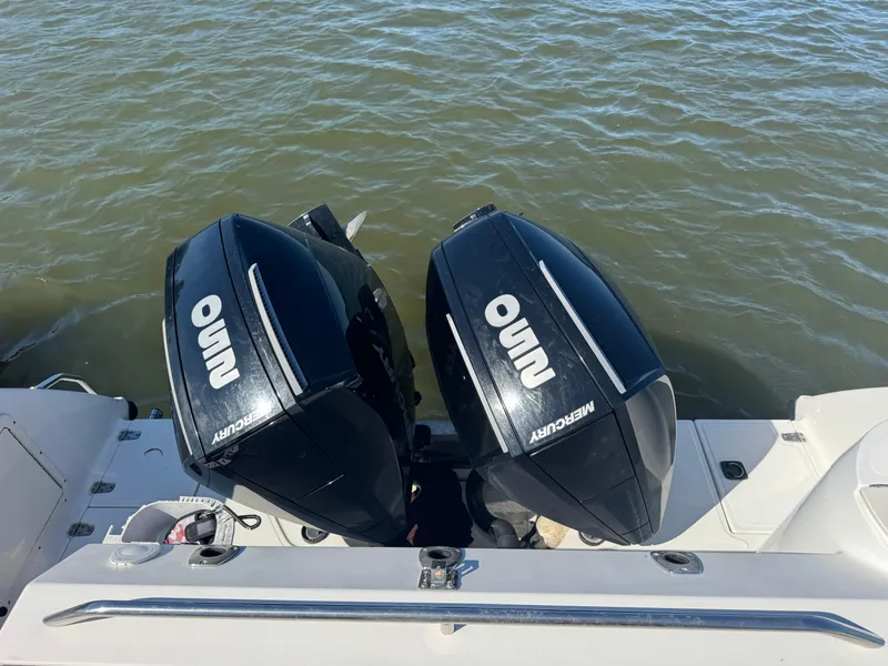 Slide: The Image of Twin Mercury outboard engines on a 1999 Boston Whaler 28 Conquest boat, floating on water. - 11