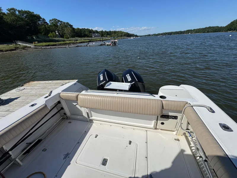 Slide: The Image of 1999 Boston Whaler 28 Conquest boat with twin Yamaha engines on a calm lake. - 12