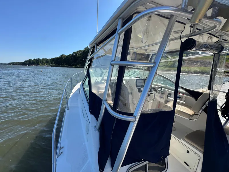 Slide: The Image of 1999 Boston Whaler 28 Conquest boat docked on a sunny day, showcasing interior and exterior features. - 14
