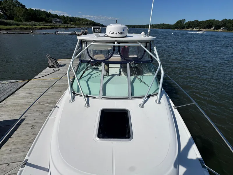 Slide: The Image of 1999 Boston Whaler 28 Conquest docked by a scenic river. - 18