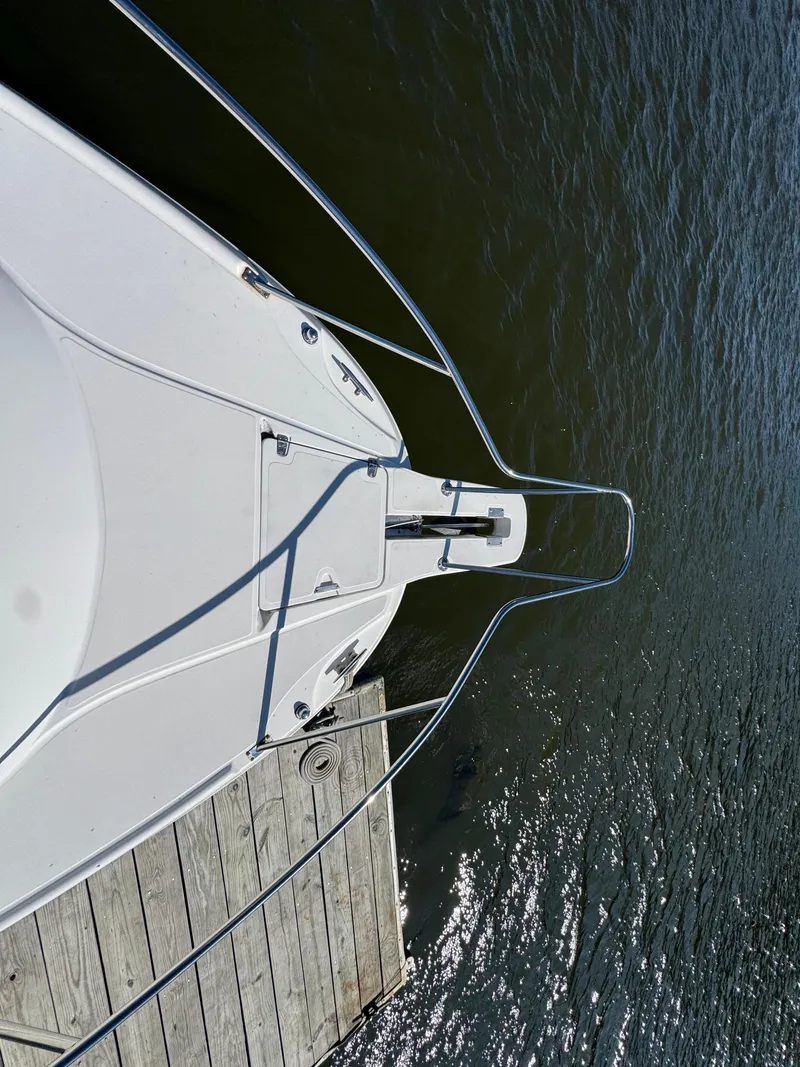 Slide: The Image of Top view of a 1999 Boston Whaler 28 Conquest docked by wooden pier. - 19