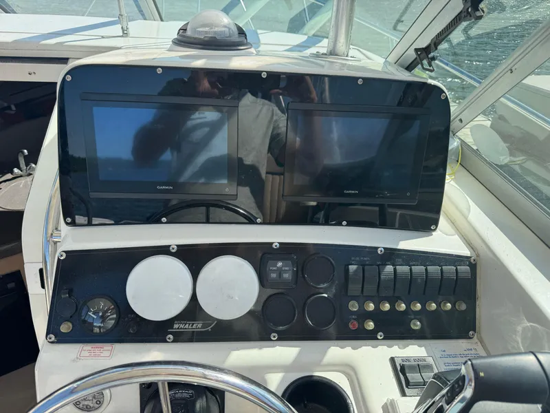 Slide: The Image of Control panel of a 1999 Boston Whaler 28 Conquest boat with Garmin displays. - 25