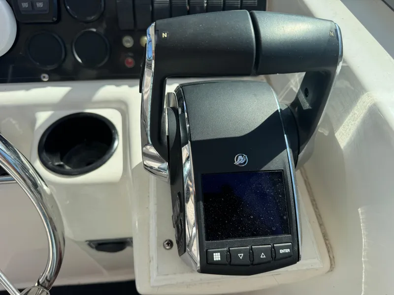 Slide: The Image of Control panel of a 1999 Boston Whaler 28 Conquest boat, featuring throttle and display. - 27