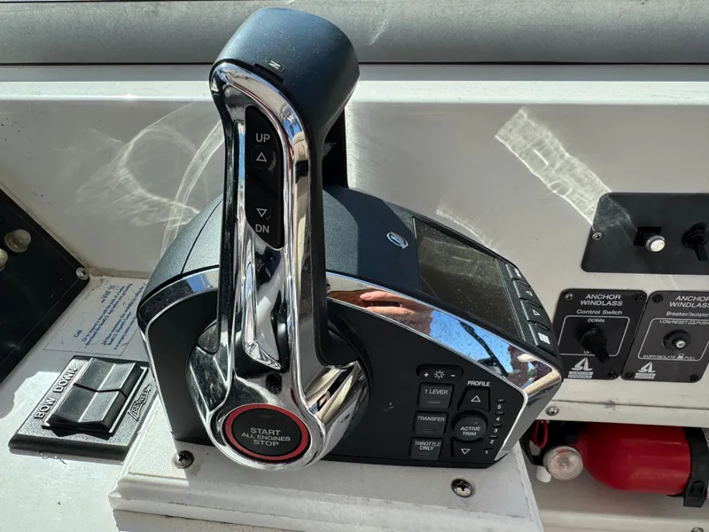 Slide: The Image of Control panel of a 1999 Boston Whaler 28 Conquest boat with throttle and switches. - 28