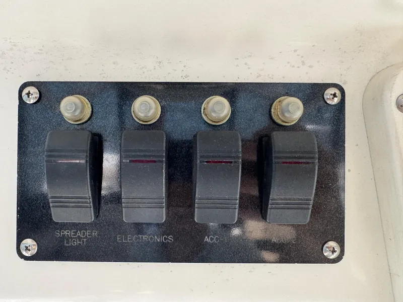 Slide: The Image of Control panel with four switches on a 1999 Boston Whaler 28 Conquest boat. - 43