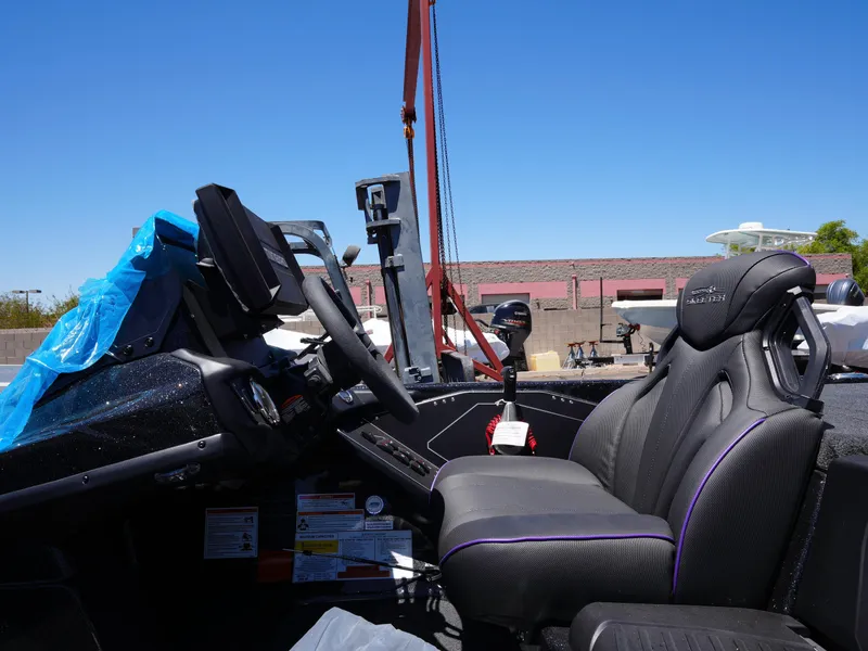 Slide: The Image of 2025 Skeeter ZXR20 boat interior with steering wheel and seats under clear blue sky. - 14