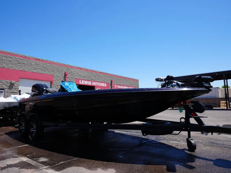 Slide: The Image of 2025 Skeeter ZXR20 boat on trailer outside Lewis Hitches building under clear blue sky. - 4