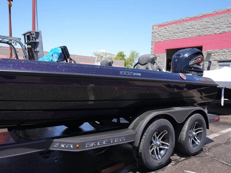 Slide: The Image of 2025 Skeeter ZXR20 boat on trailer, parked outdoors, showcasing sleek design and modern features. - 8