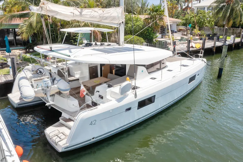 Slide: The Image of Aerial view of a 2017 Lagoon 42 catamaran docked beside a motorboat and kayaks. - 10