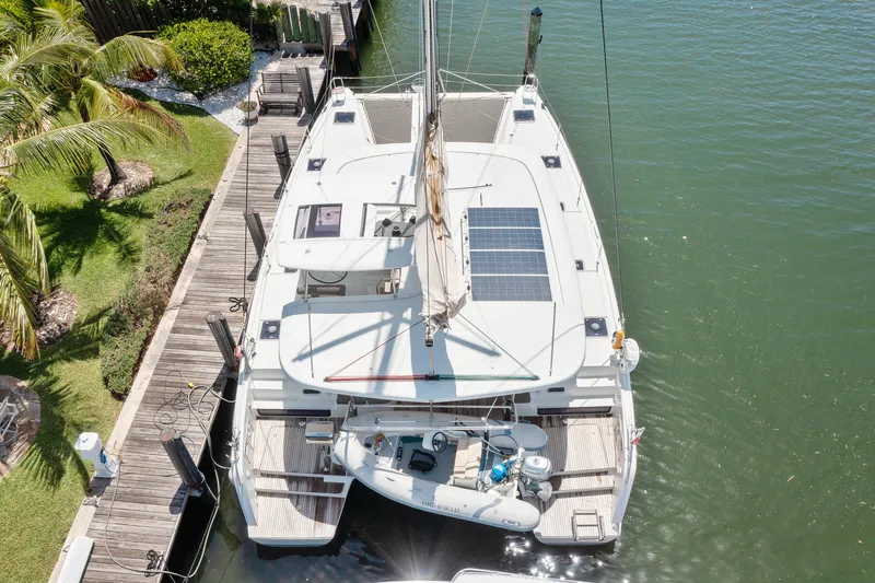 Slide: The Image of Aerial view of a 2017 Lagoon 42 catamaran docked by a lush, tropical shoreline. - 11