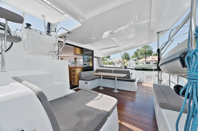 Slide: The Image of 2017 Lagoon 42 Owners Version catamaran docked by tropical waterfront homes. - 14