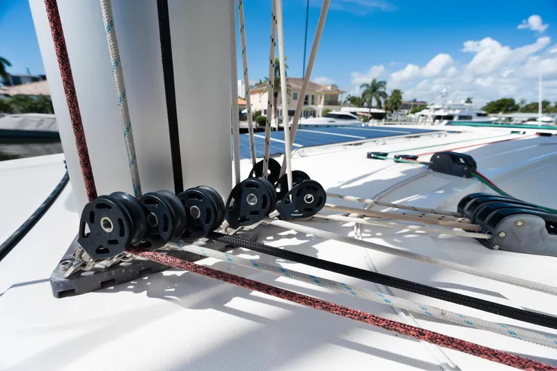 Slide: The Image of 2017 Lagoon 42 catamaran docked by a canal with palm trees and clear skies. - 55