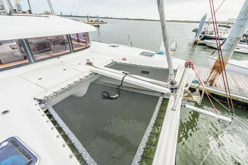 Slide: The Image of 2017 Lagoon 42 catamaran docked at a marina under a cloudy sky. - 80