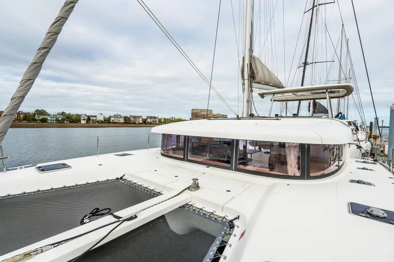 Slide: The Image of Docked Lagoon 42 catamarans from 2017 at a marina, with cityscape in the background. - 83