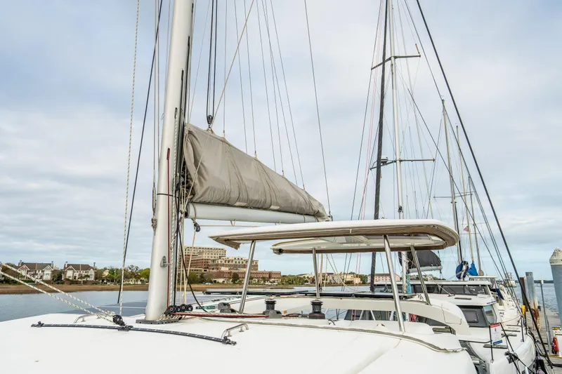 Slide: The Image of 2017 Lagoon 42 catamaran docked in a marina, surrounded by other boats. - 88
