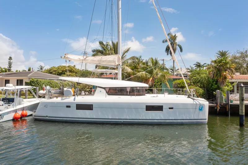 Slide: The Image of Aerial view of a marina with a 2017 Lagoon 42 catamaran docked, surrounded by waterfront homes. - 9