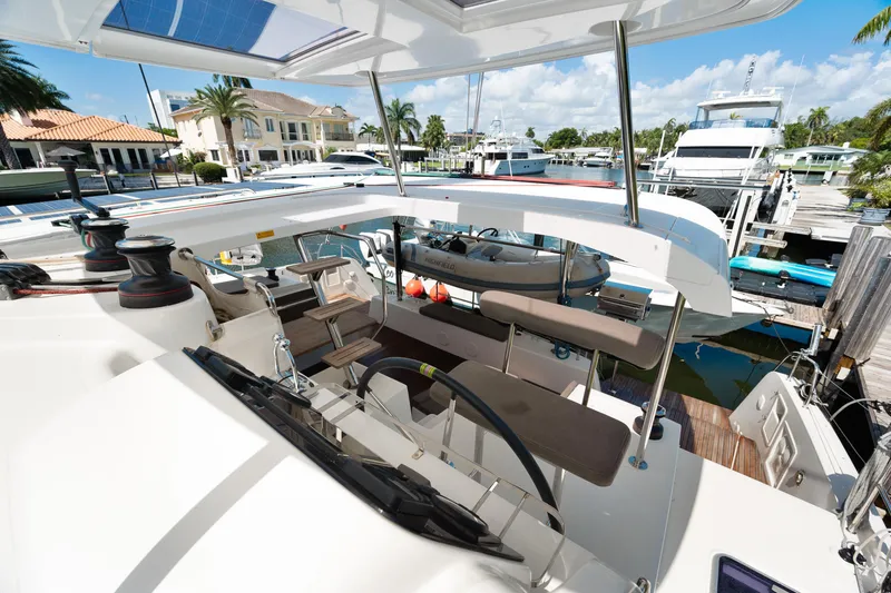 Slide: The Image of Helm of 2017 Lagoon 42 catamaran with navigation instruments, surrounded by tropical greenery. - 48