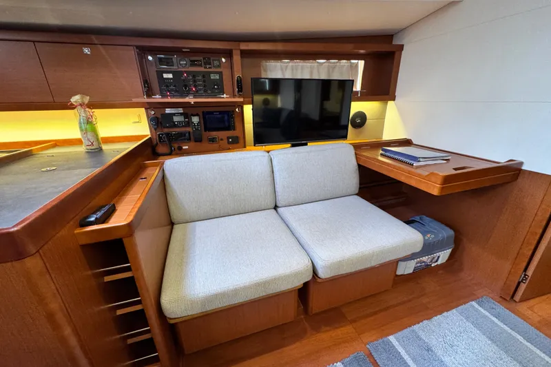 Slide: The Image of Interior of 2016 Beneteau Oceanis 48 yacht with cozy seating and navigation equipment. - 15