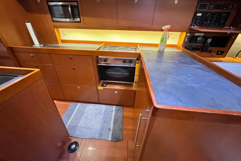 Slide: The Image of Modern kitchen in 2016 Beneteau Oceanis 48 yacht with wood cabinetry and stainless steel appliances. - 21
