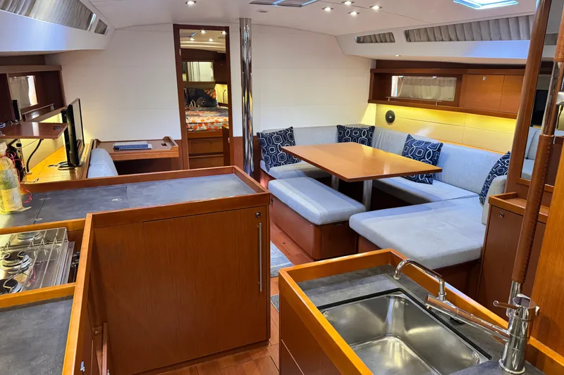 Slide: The Image of Interior of 2016 Beneteau Oceanis 48 yacht with modern kitchen and cozy seating area. - 23