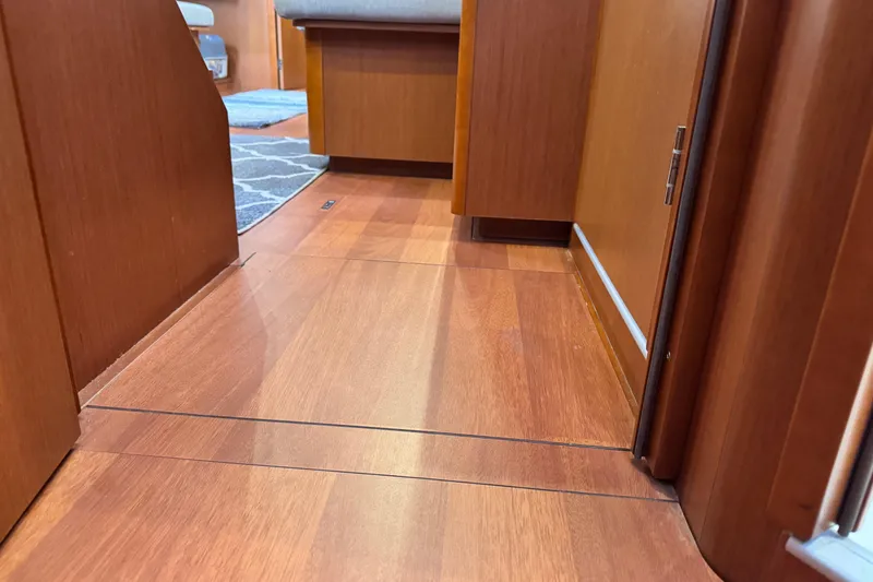 Slide: The Image of Interior view of 2016 Beneteau Oceanis 48 yacht with wooden flooring and seating area. - 27