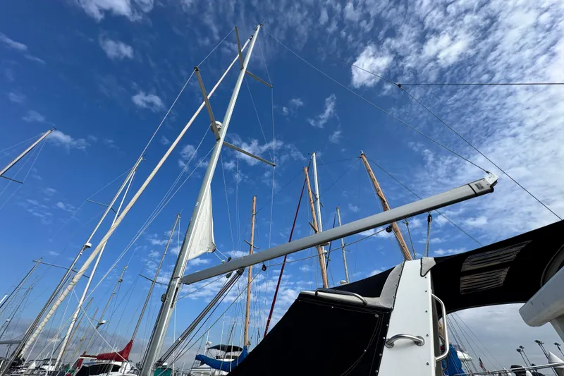 Slide: The Image of Sailboat masts against a blue sky, featuring a 2016 Beneteau Oceanis 48. - 3
