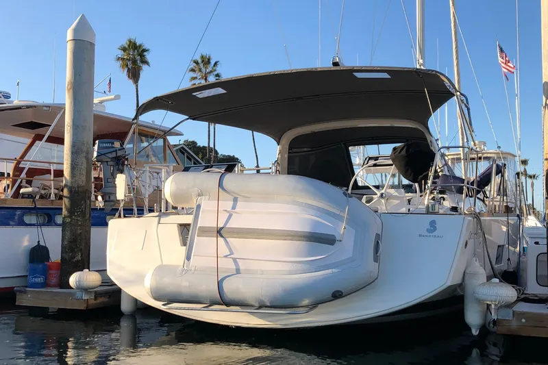 Slide: The Image of 2016 Beneteau Oceanis 473 yacht docked with inflatable boat, palm trees in background. - 45