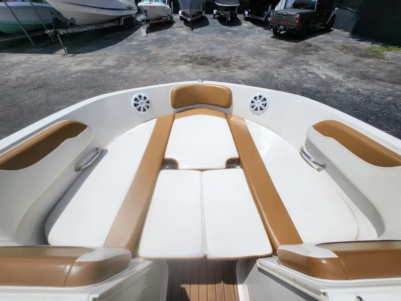 Slide: The Image of 2021 Bayliner VR6 Bowrider OB with tan and white seating in a boatyard. - 16