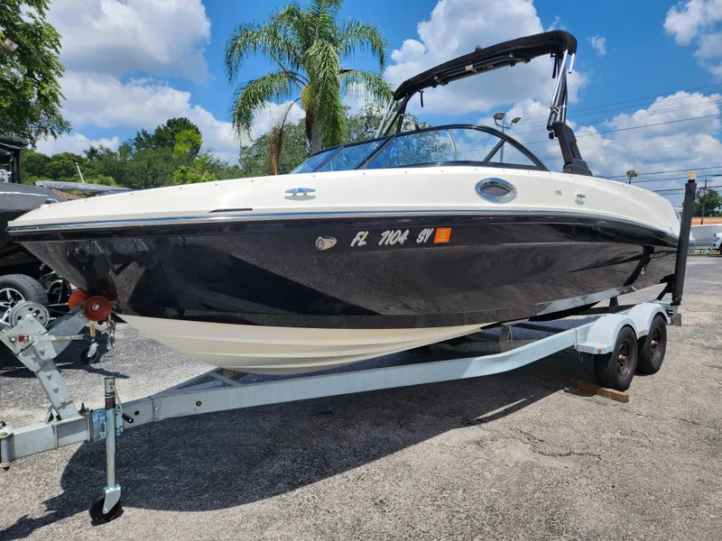 Slide: The Image of 2021 Bayliner VR6 Bowrider OB on trailer, parked outdoors under a clear blue sky. - 18