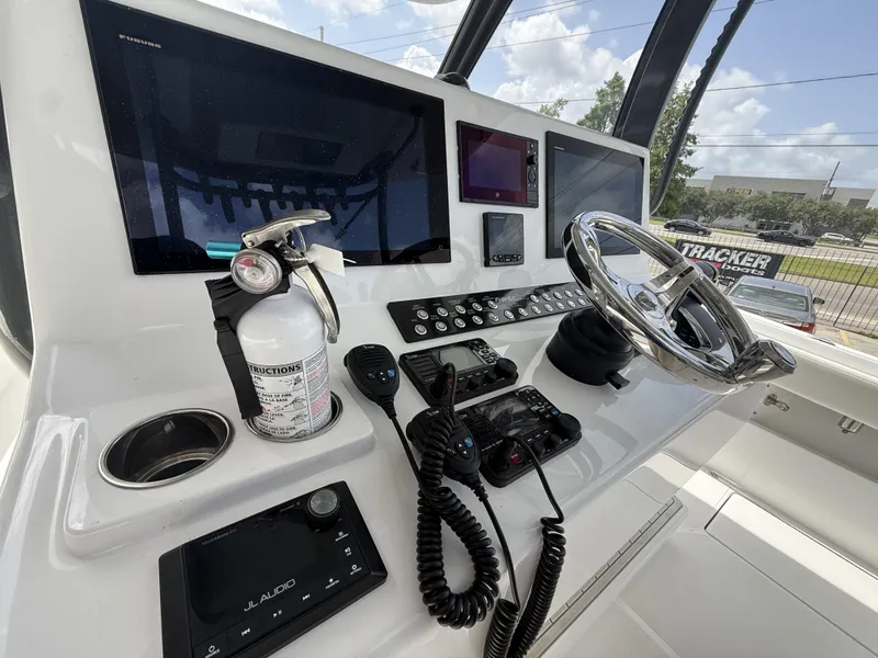 Slide: The Image of 2024 Front Runner 39 CC boat dashboard with steering wheel, electronics, and fire extinguisher. - 26