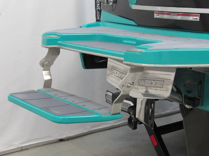 Slide: The Image of 2021 Malibu Wakesetter 23 LSV boat on trailer, teal and black design, in indoor setting. - 3