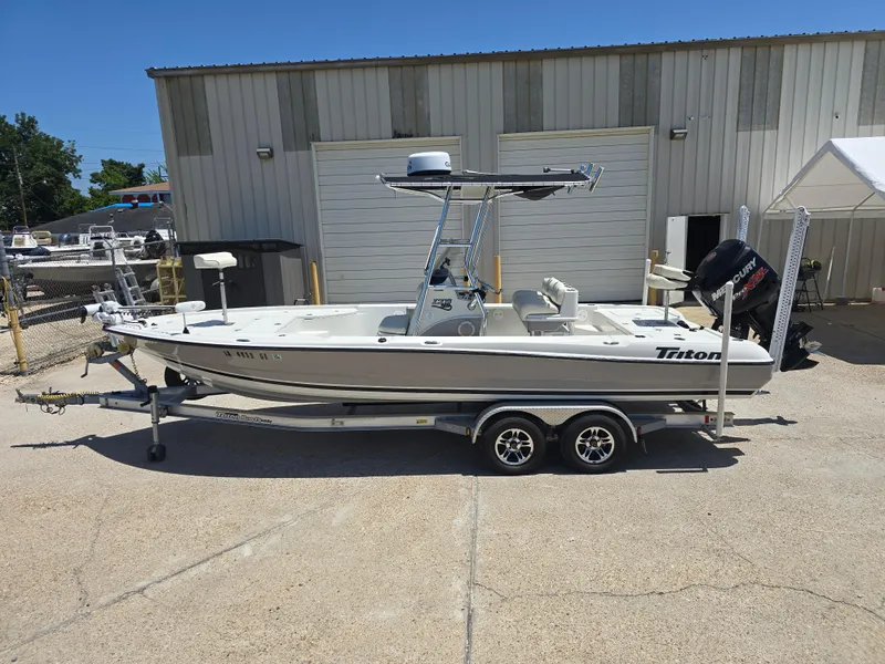 Slide: The Image of 2014 Triton 240 LTS Pro boat on trailer, parked outside a warehouse. - 1