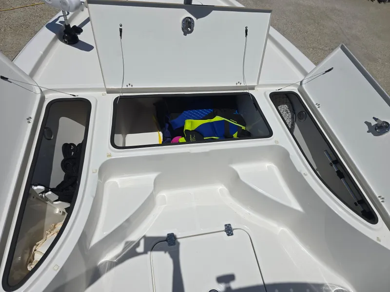 Slide: The Image of 2014 Triton 240 LTS Pro boat storage compartments with open hatches and visible gear. - 10
