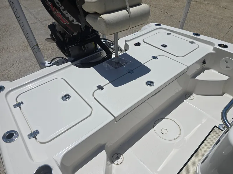 Slide: The Image of 2014 Triton 240 LTS Pro boat deck with storage compartments and Mercury engine. - 13