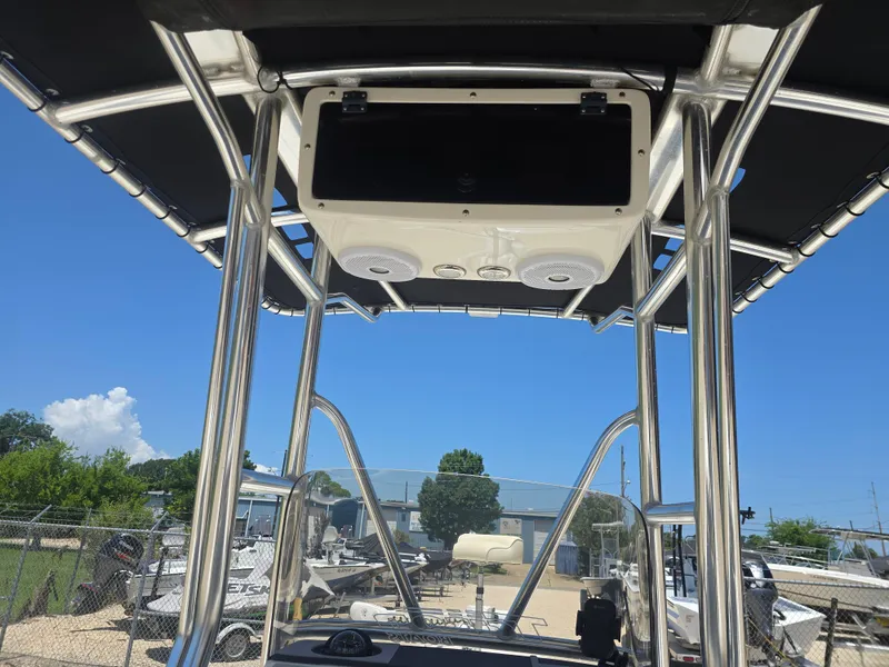 Slide: The Image of Triton 240 LTS Pro 2014 boat with T-top and speakers, parked outdoors. - 14