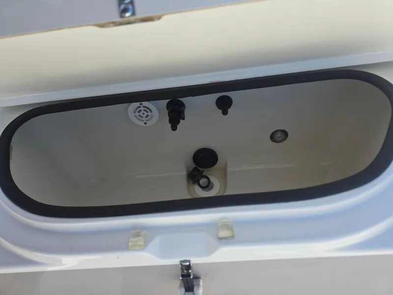 Slide: The Image of 2014 Triton 240 LTS Pro livewell interior with drain and fittings. - 17