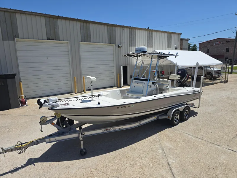 Slide: The Image of 2014 Triton 240 LTS Pro boat on trailer, parked outside industrial building. - 3