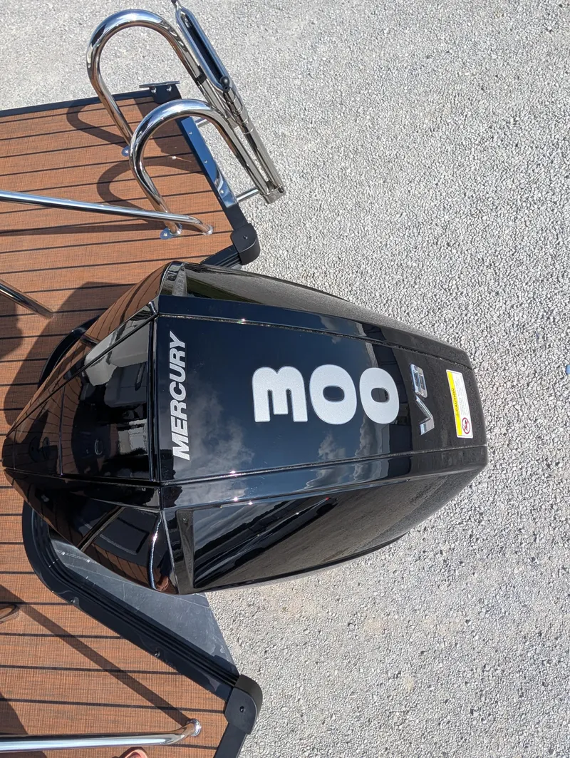 Slide: The Image of Boat with Mercury V8 engine on Manitou Explore 2025 model, docked on wooden platform. - 15