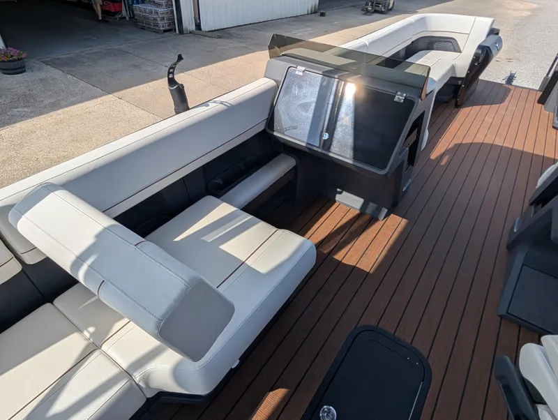 Slide: The Image of 2025 Manitou Explore boat interior with sleek seating and wood-style flooring. - 19