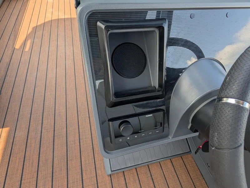 Slide: The Image of 2025 Manitou Explore dashboard with speaker and control panel on wooden deck. - 23